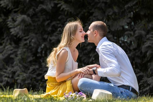 Stel zit dicht bij elkaar op de bank en praat ontspannen over liefde en hun relatie