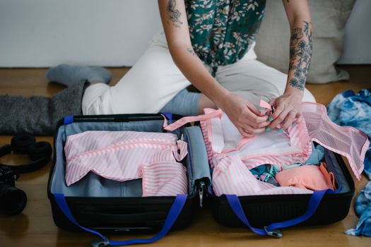 Gezin pakt koffers in met kleding, gadgets en checklist voor een zomervakantie