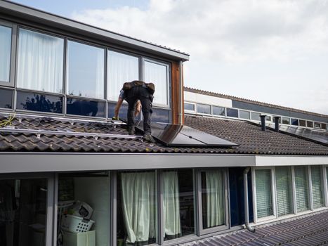 Thuisbatterij naast omvormer in een modern huis met zonnepanelen op het dak in 2026