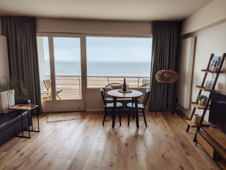 Vrouw leest het linda vakantieboek 2026 op een zonnig terras naast een koffer en zonnebril